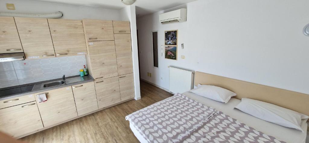 a small bedroom with a bed and a kitchen at Daisy apartment in Ajdovščina