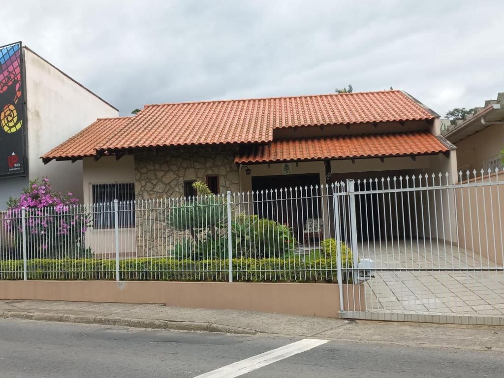 a white fence in front of a house at Casa Itoupava Norte in Blumenau