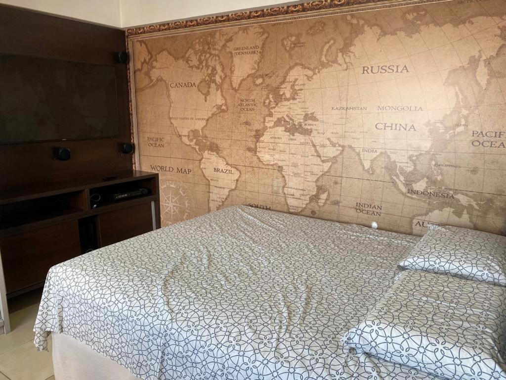 a bedroom with a map of the world on the wall at Loft no Condomínio Celita Franca Executive ApartHotel in Feira de Santana