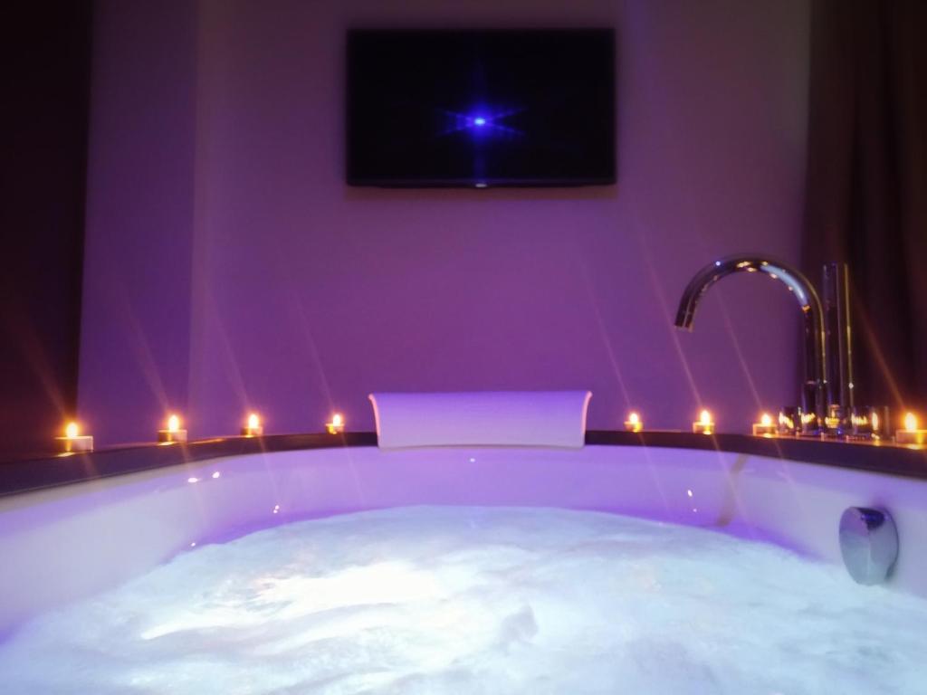 a bathroom with a tub with a tv and lights at MB Boutique Hotel - Adults Recommended in Nerja