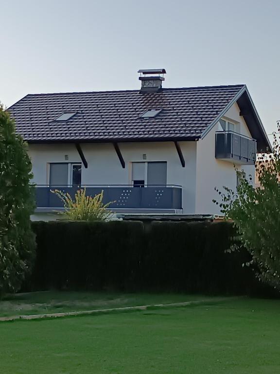 a white house with a black roof at Apartma pri Renati in Celje