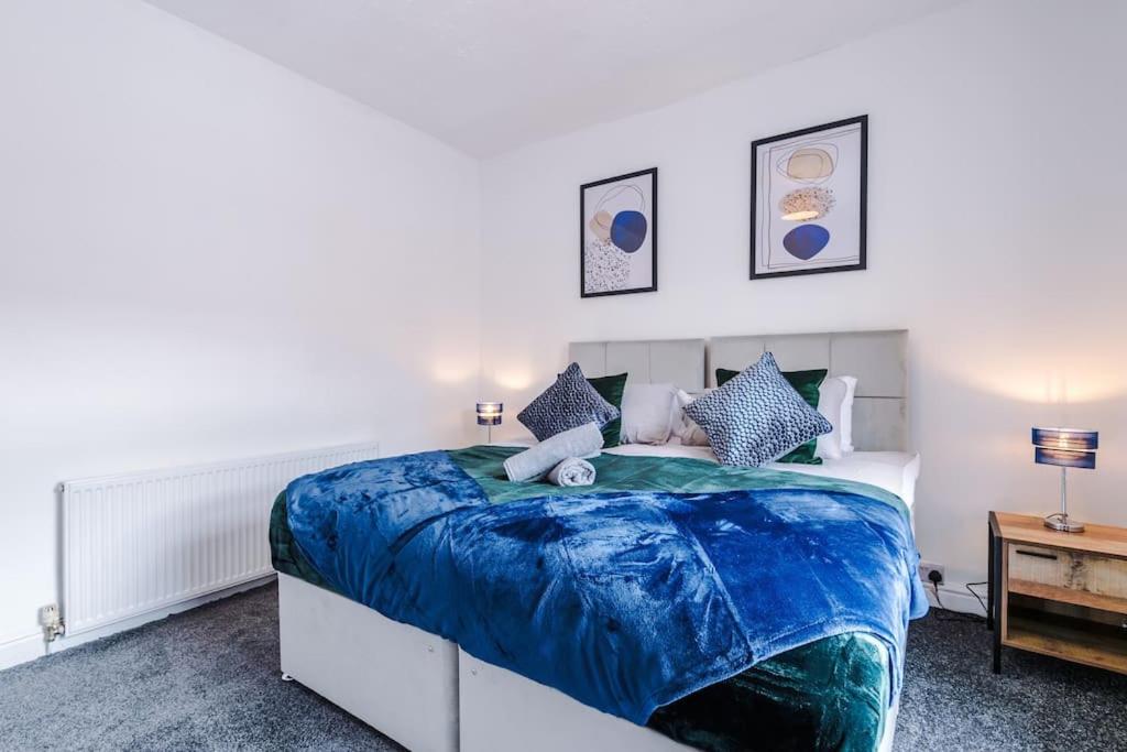 a bedroom with a bed with a blue comforter at Luxurious Living 2 BR Home MCR in Manchester