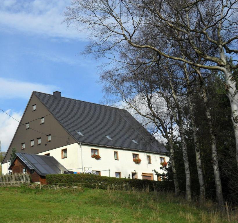 a large white barn with a black roof at Ferienunterkünfte Kreißl Oberwiesenthal in Kurort Oberwiesenthal