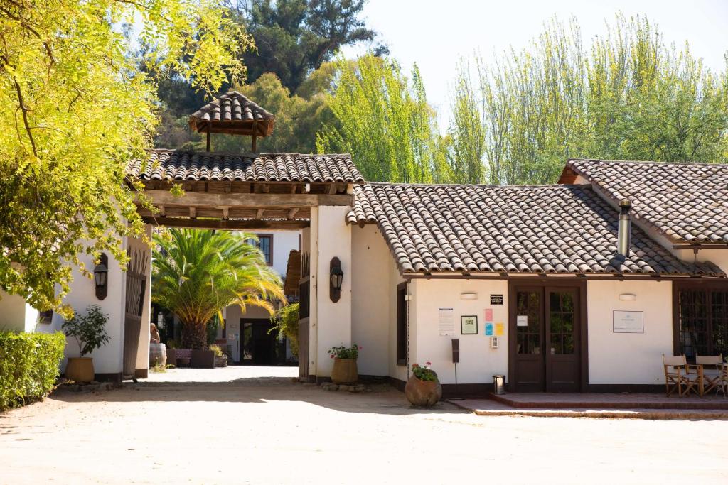 una entrada a una casa con una puerta y árboles en Hacienda Historica Marchigue, en Marchihue