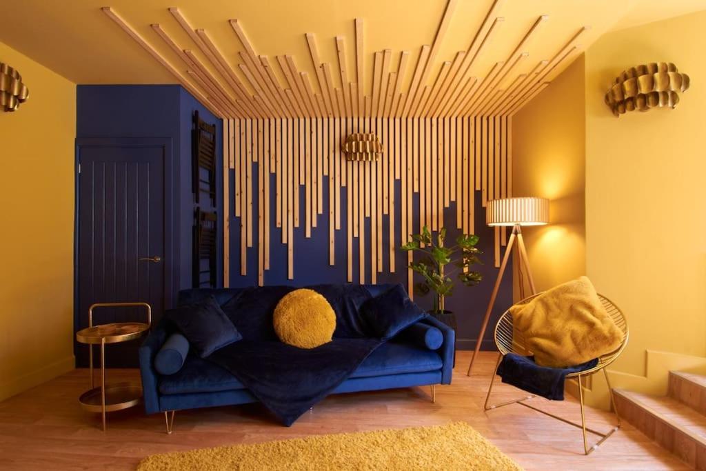 - un salon avec un canapé bleu dans une pièce murale dans l'établissement Knightstone Apartment, à Weston-super-Mare