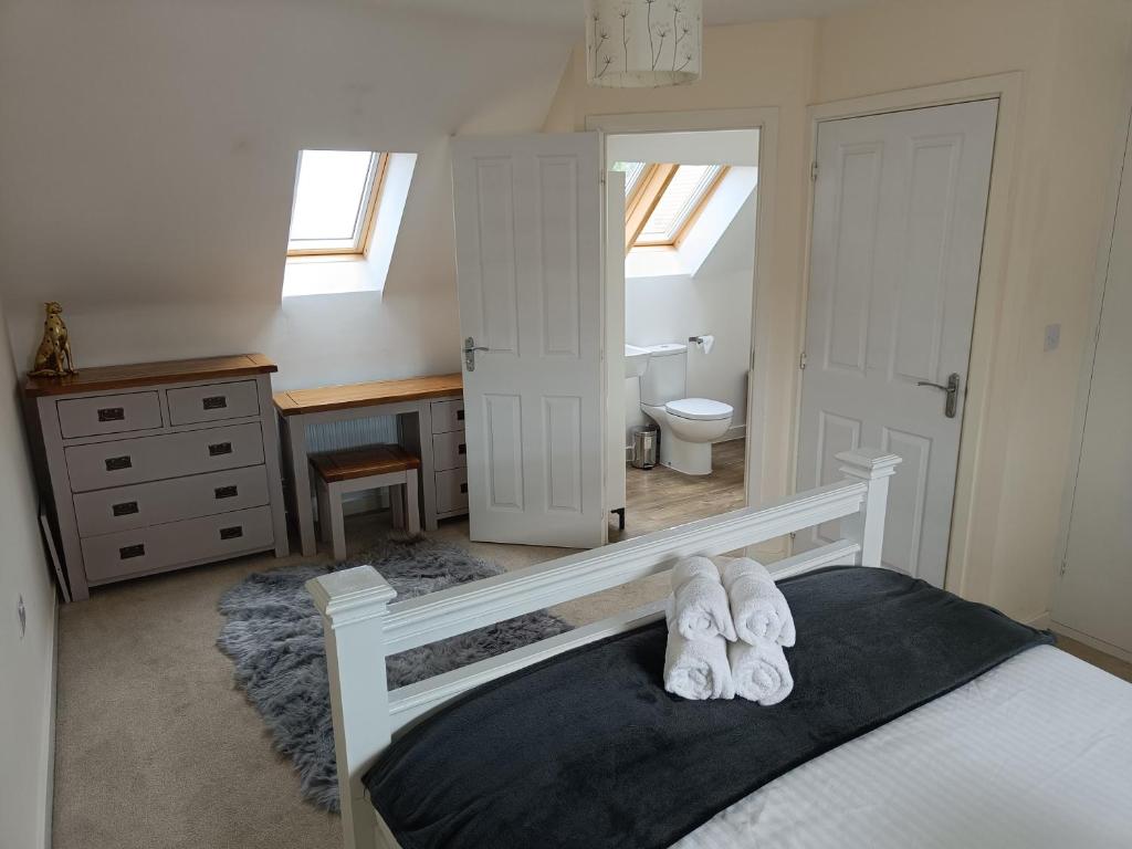 a bedroom with a bed with white towels on it at 3 bedroom townhouse near Bicester Village in Bicester