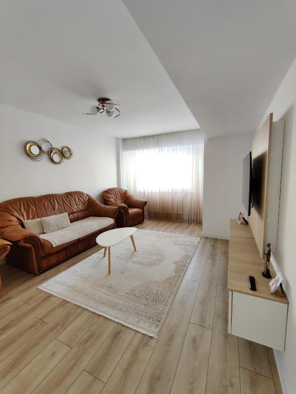 a living room with a couch and a television at Ania's Apartment in Horezu