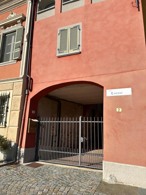 a red building with a gate and a fence at La tana di Piozzo in Piozzo