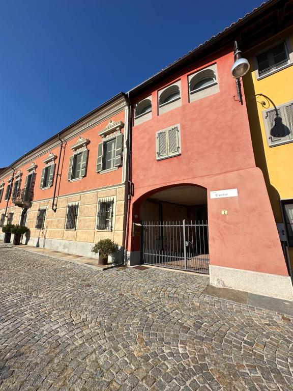 a red brick building with an archway in a street at La tana di Piozzo in Piozzo