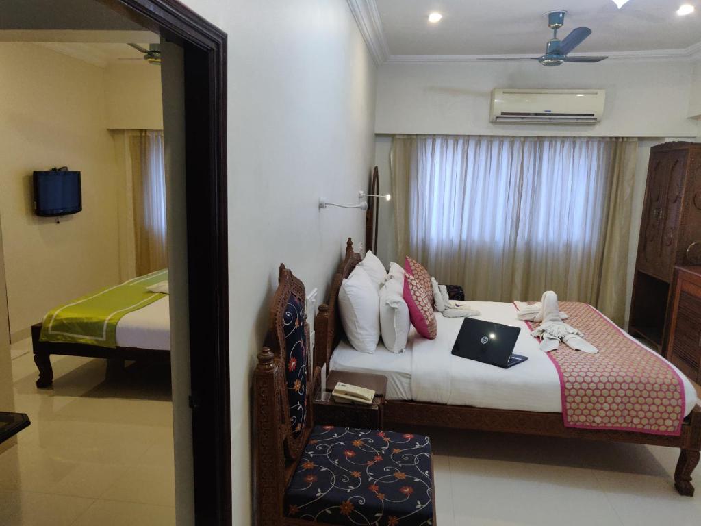 1 dormitorio con 1 cama con ordenador portátil en Chandra Inn, en Jodhpur