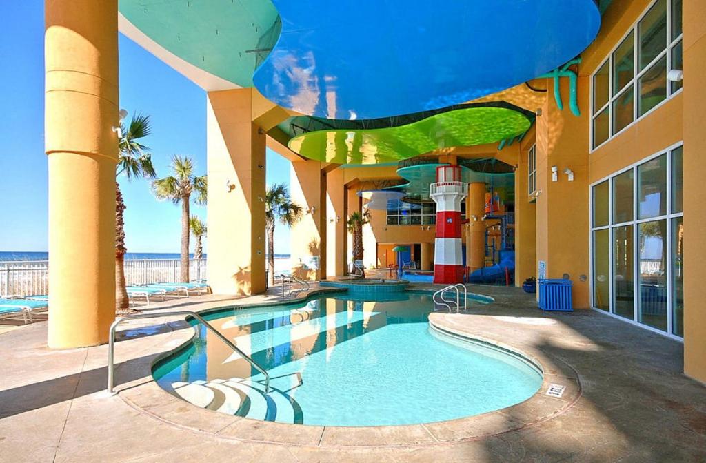 a building with a swimming pool in front of the ocean at Splash Beach Resort by Panhandle Getaways in Panama City Beach
