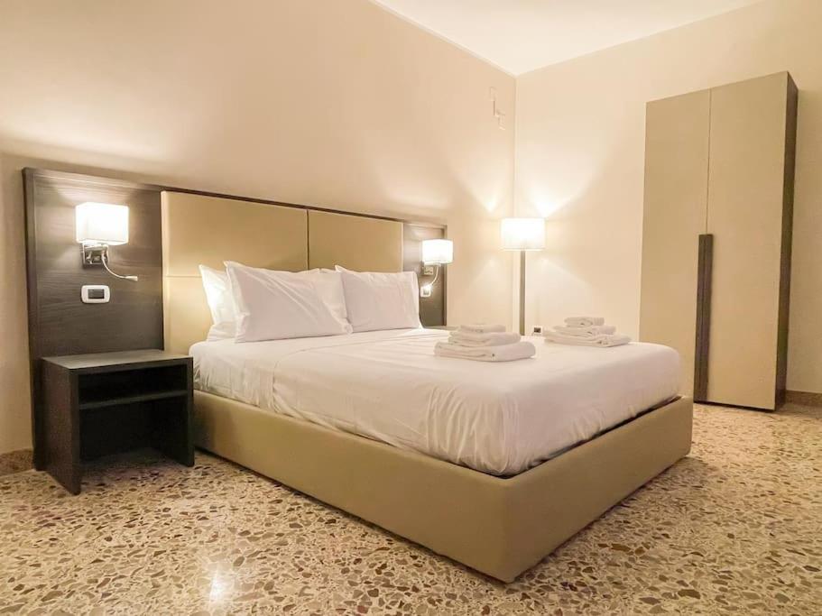 - une chambre dotée d'un grand lit avec des draps et des oreillers blancs dans l'établissement Brain Loft Pagani, à Pagani