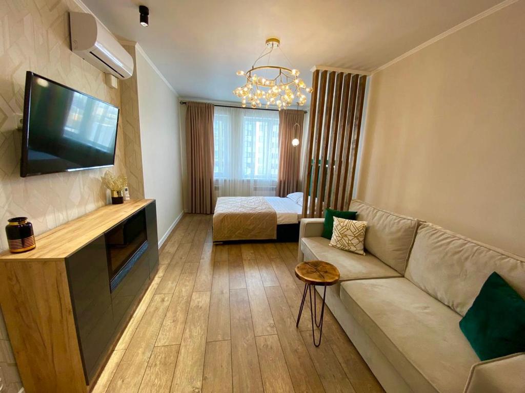 - un salon avec un canapé et une télévision dans l'établissement Apartament LETO, à Astana