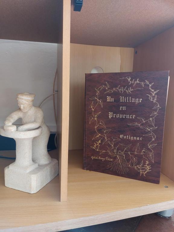 a book sitting on a shelf next to a statue at La Quiétude in Cotignac