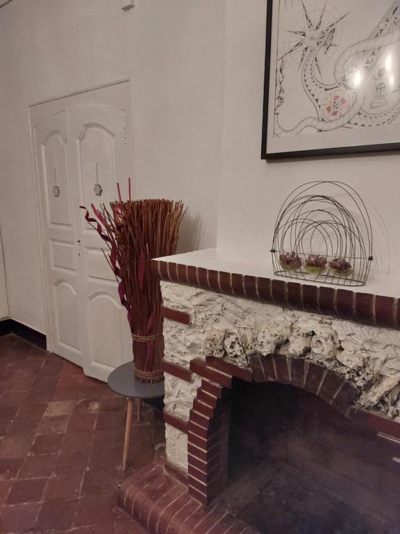 a room with a fireplace with a vase next to a door at La Quiétude in Cotignac