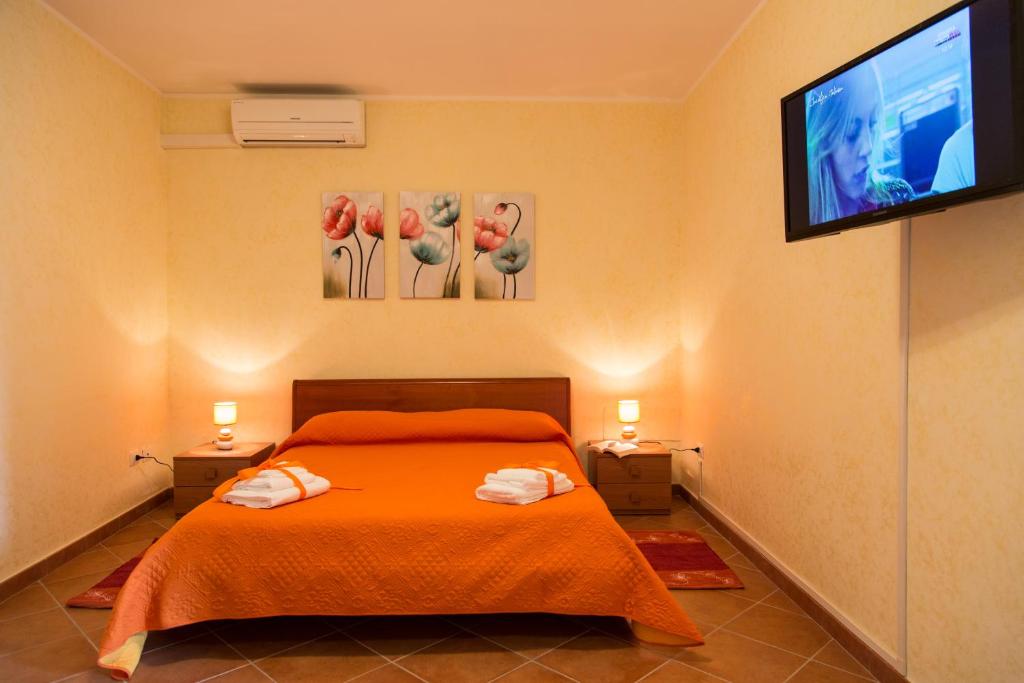 a bedroom with a bed and a flat screen tv at Le Stanze del Re in Lamezia Terme