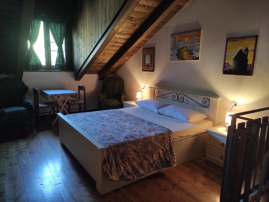 a bedroom with a large bed and a table at La dimora delle corti in Vanzone