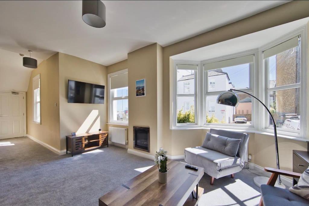 a living room with a couch and a table at Stylish beachfront apartment in historic Deal in Kent