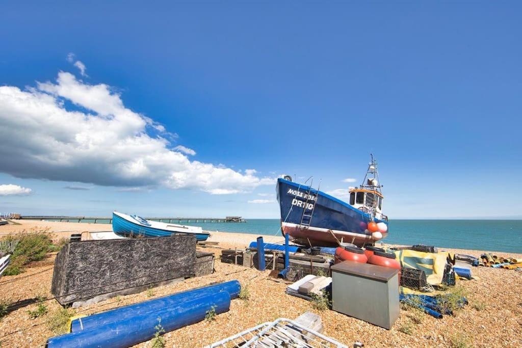 a group of boats sitting on the beach at Stylish beachfront apartment in historic Deal in Kent