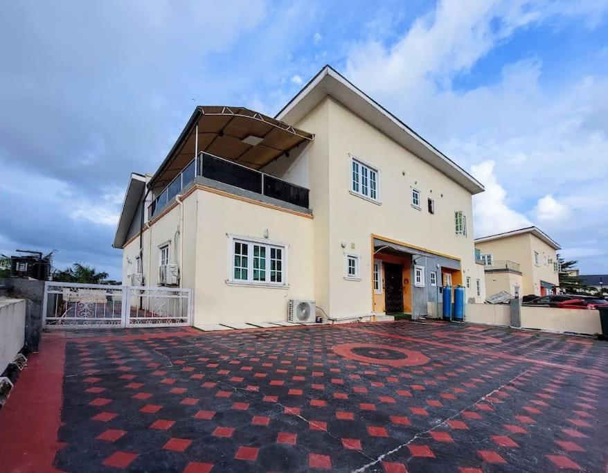 a large white house with a brick driveway at BBAN-Luxurious 4 Bedroom House in Lekki Ajah Lagos in Lekki