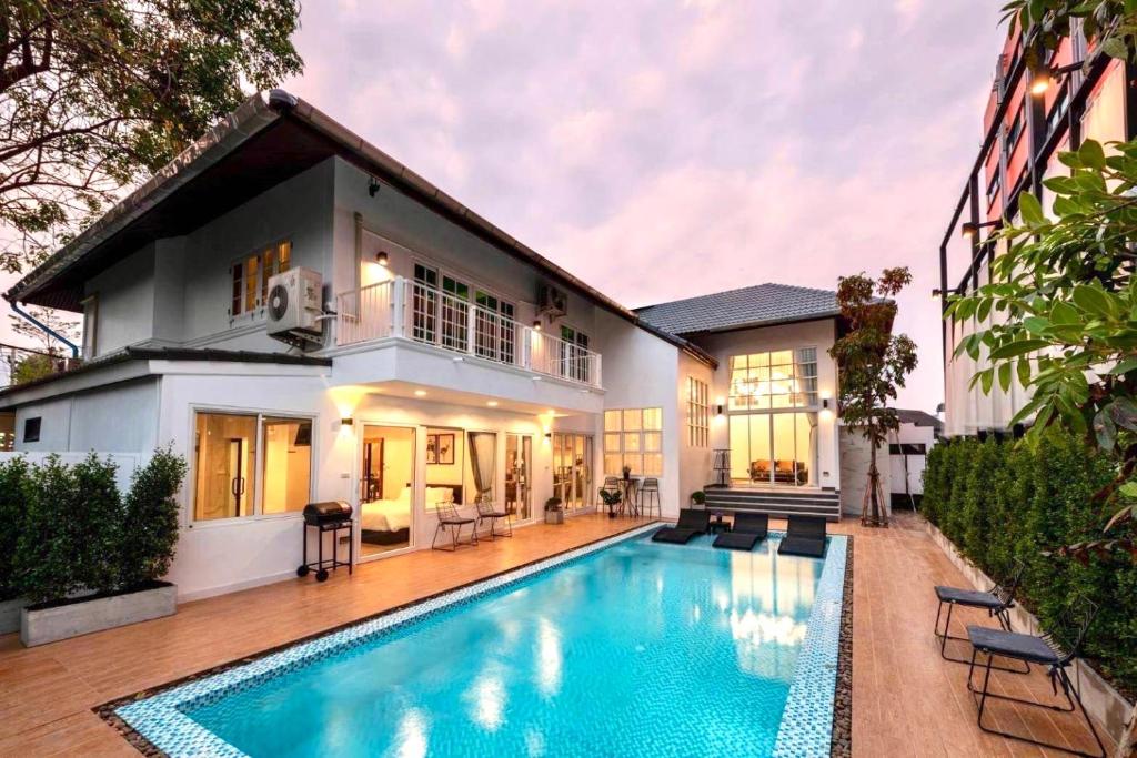 清邁的住宿－Nimman Villa 17 Chiangmai - SHA PLUS，一座房子前面设有游泳池