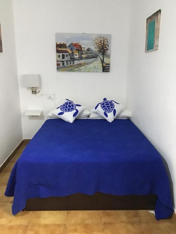 sypialnia z niebieskim kocem na łóżku w obiekcie Apartamentos Playamar II w mieście Valle Gran Rey