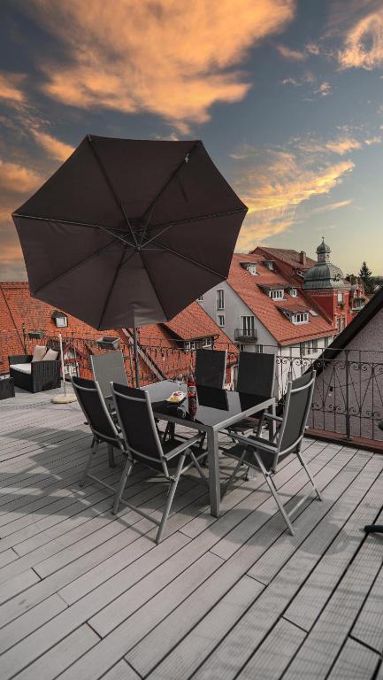a table and chairs with an umbrella on a roof at B&B Ferienwohnung mit bester Aussicht/Lage in Wangen im Allgäu