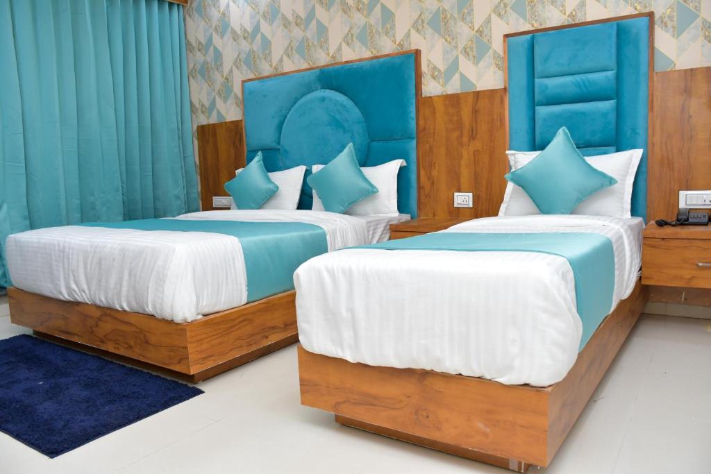 two beds in a room with blue and white at Hotel Green Park in Gandhinagar