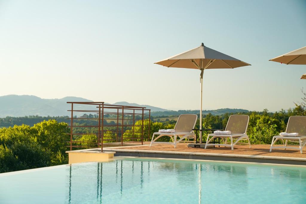 卡斯泰洛城的住宿－Agriturismo Il Sarale - Umbria，一个带两把椅子和遮阳伞的游泳池
