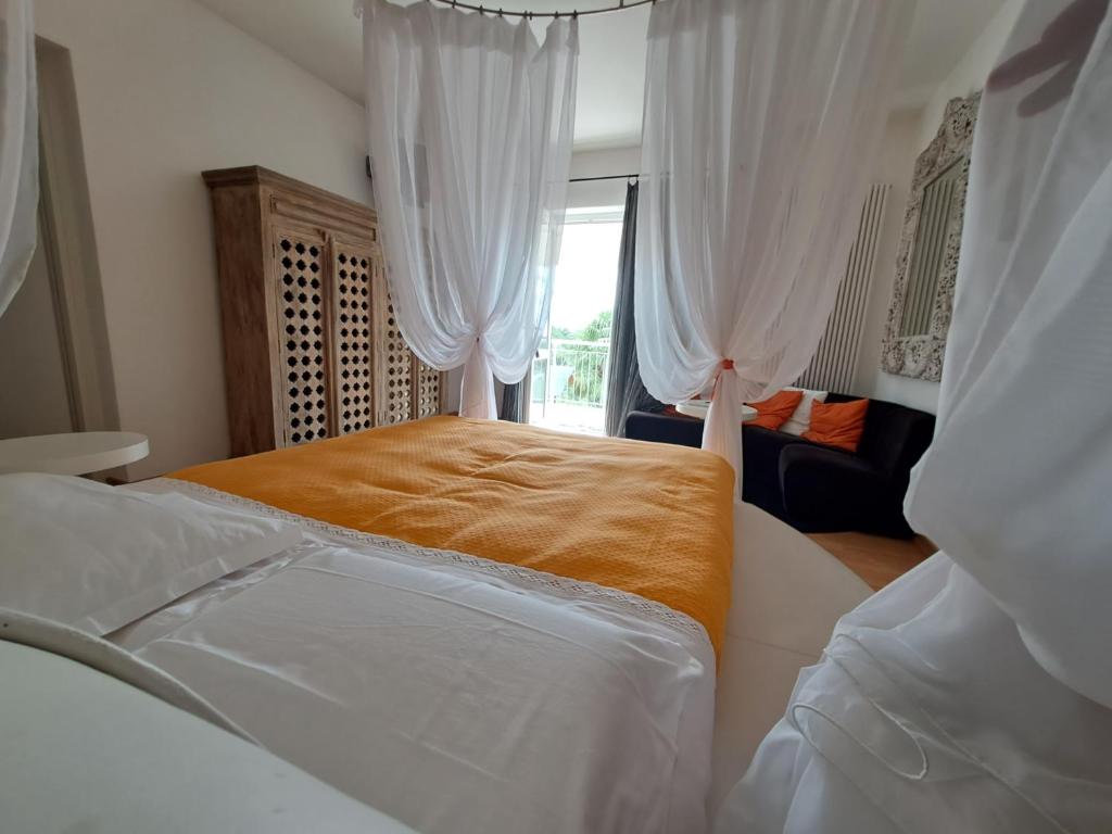 a bedroom with a bed with white curtains and a window at La casa de riki 