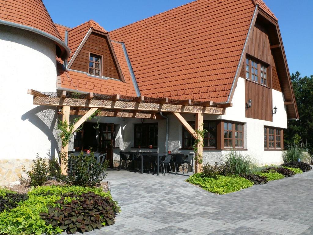 a large white building with an orange roof at Kádárta Vendéglő Panzió in Veszprém