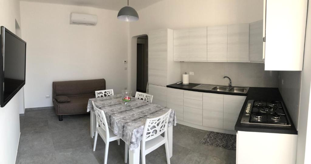 - une cuisine avec une table, des chaises et un évier dans l'établissement La casa di MeT, à Gallipoli