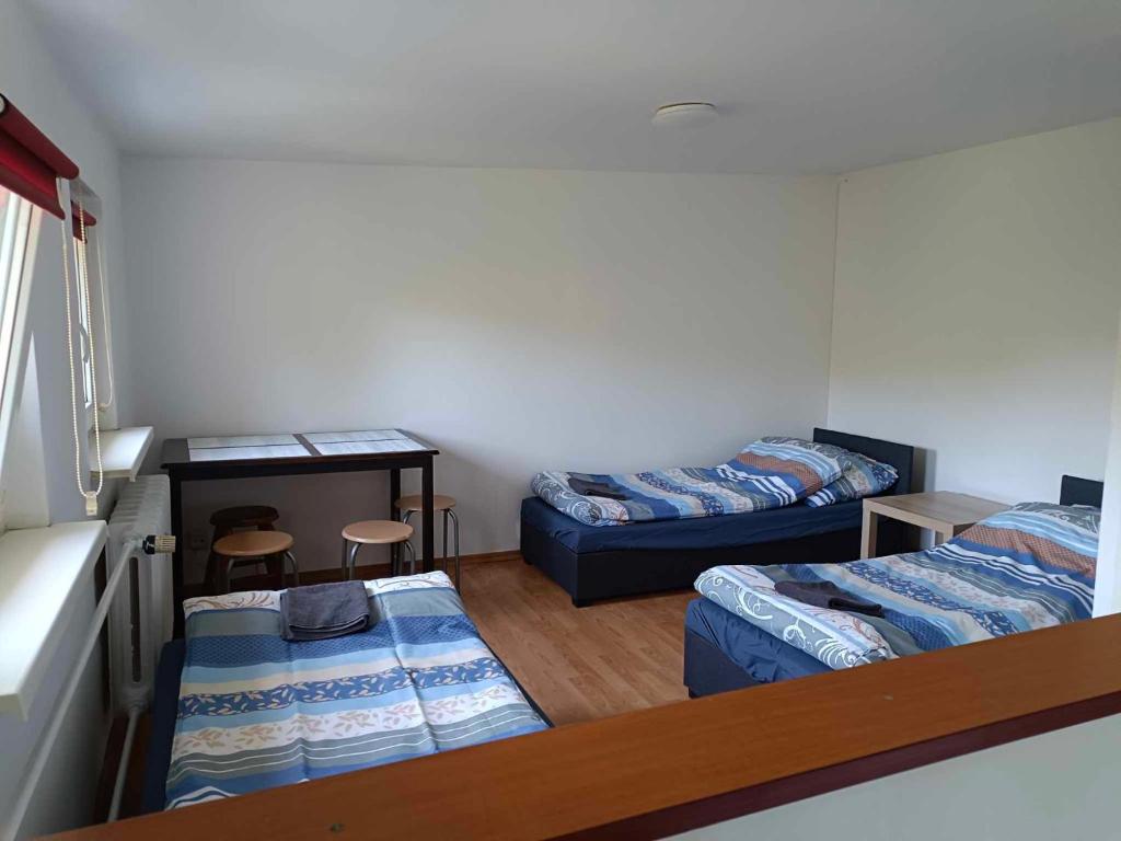 a small room with two beds and a table and chairs at Odrodzenia 7 in Toruń