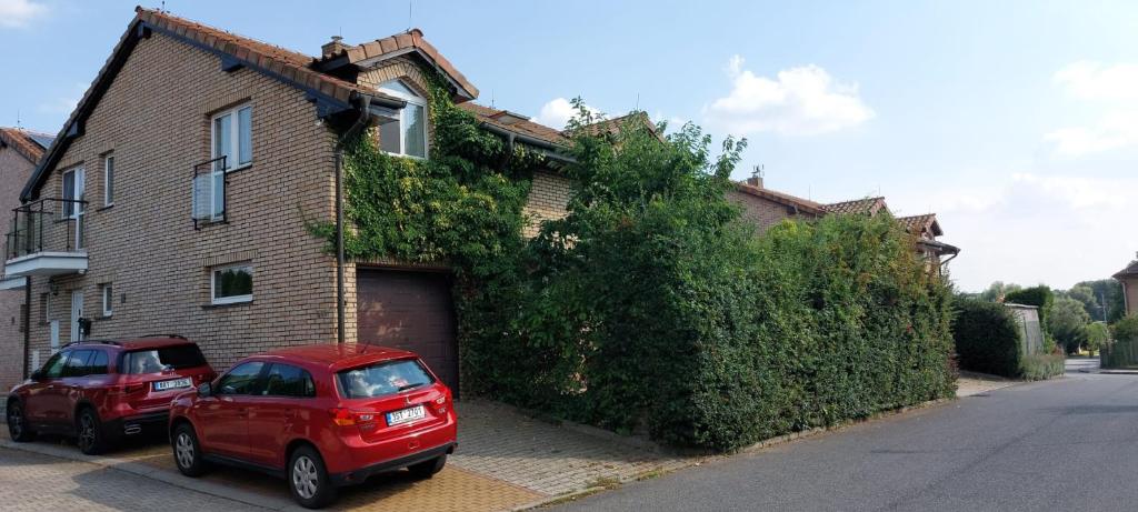 a red car parked in front of a brick house at House in beautiful suburb of Prague in Dolní Břežany