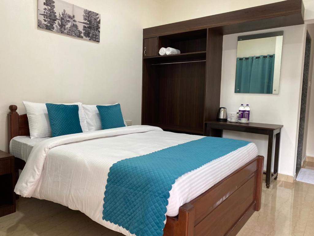 a bedroom with a large bed with blue and white sheets at Kepler Stay By AT Hotel Collection in Majorda