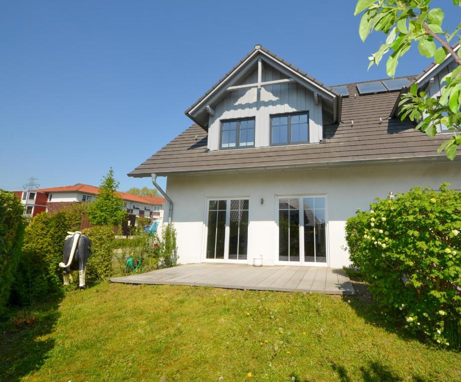 a large white house with a large yard at Luxuriöse Doppelhaushälfte am grünen Rande von Hamburg in Oststeinbek