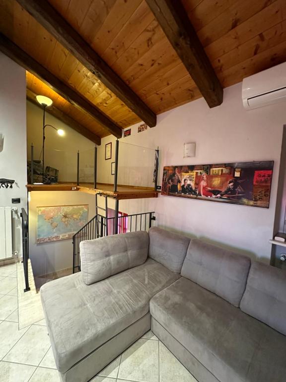 a living room with a gray couch in a room at La tana di Piozzo in Piozzo