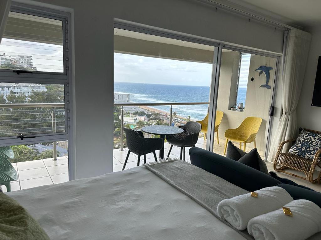 a bedroom with a bed and a view of the ocean at 514 Umdloti Resort Spectacular breakers view in Umdloti