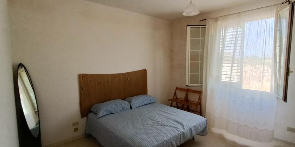 a small bedroom with a bed and a window at VersoSUD in Marsala