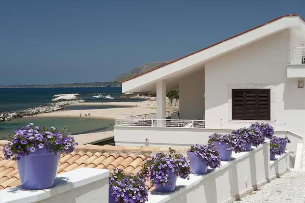 a row of purple flowers in blue pots on a fence at Terrazza Sul Mare by Le Dhome Sicily in Trappeto