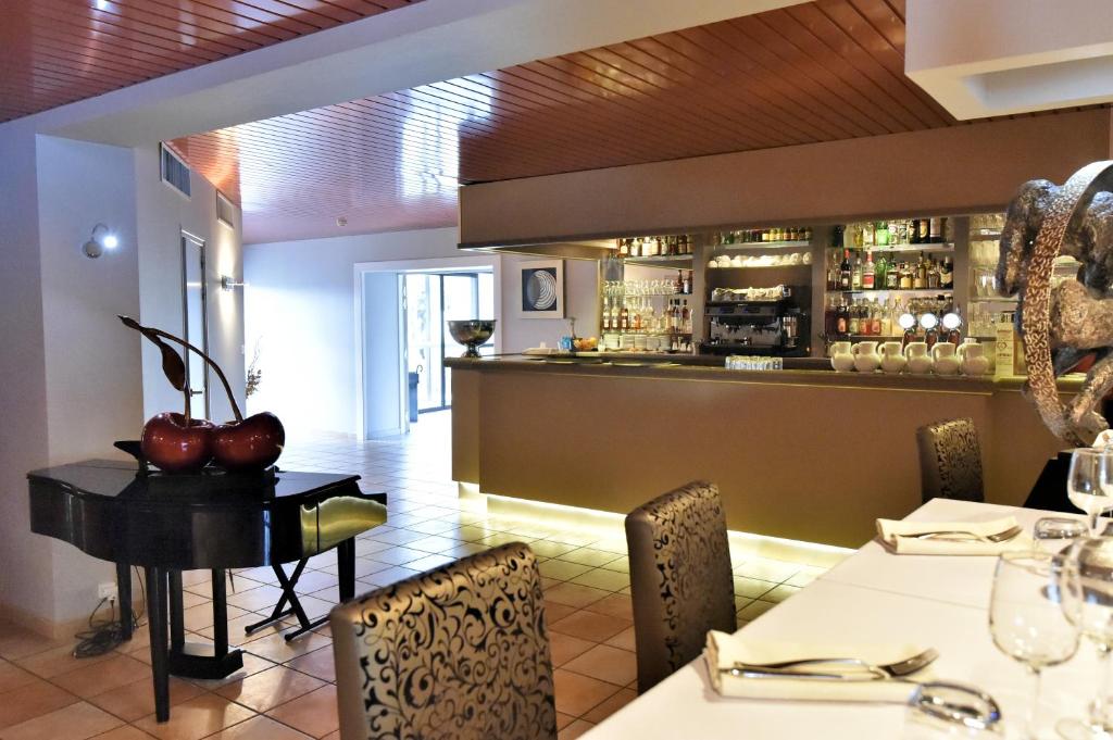 a restaurant with a table and chairs and a bar at Le Domaine des Oliviers in Pierrelatte