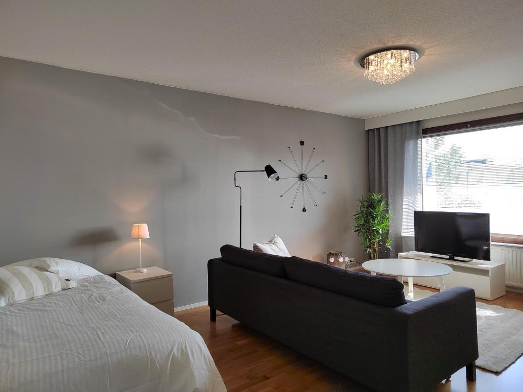 a living room with a couch and a clock on the wall at City Apartment Tieva in Rovaniemi