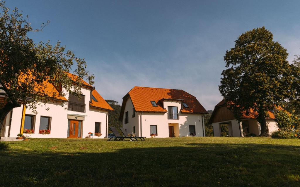 a large white house with an orange roof on a field at Hiša na Ravnah in Pišece