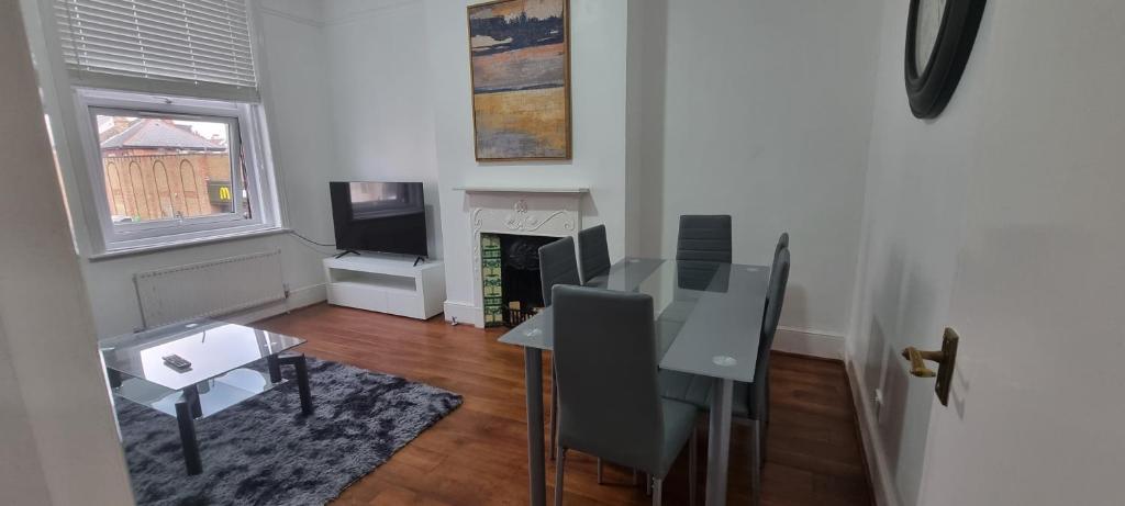 a living room with a dining table and a television at Cricklewood Broadway Guest Home in London