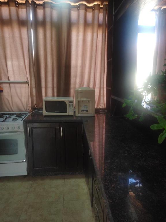 a kitchen with a stove and a microwave on a counter at R K Roof in Amman