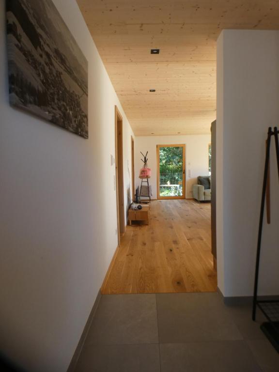 un pasillo de una casa con paredes blancas y suelo de madera en Stylische Fewo in Bestlage in neugebautem Holzhaus mit Oberstaufen Plus, en Oberstaufen