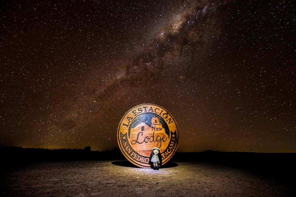 a starry night with a person standing in the sand at Nueva Lodge Estación San Pedro de Atacama in San Pedro de Atacama