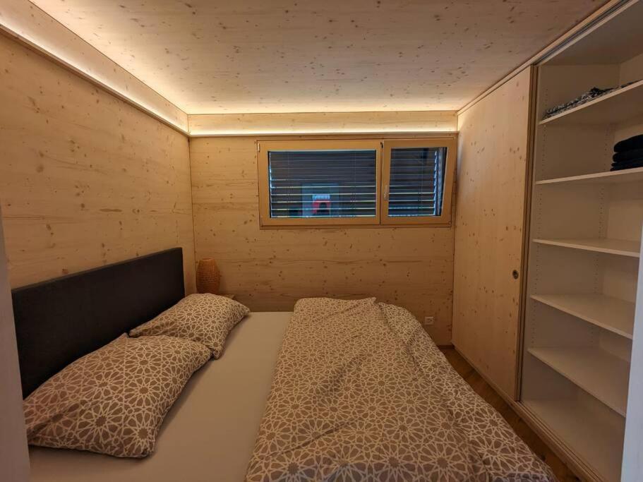 a small bedroom with a bed and a window at TinyHouse - (D)ein Ferienhaus in Schellenberg