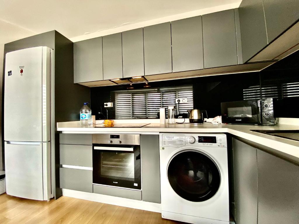 a kitchen with a washing machine and a refrigerator at Semerkant Line Blokları in Esenyurt