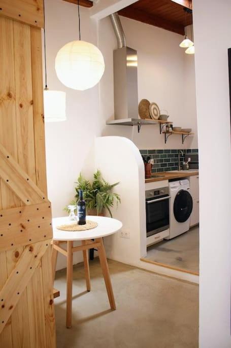 a small kitchen with a table and a stove at Cozy Townhouse With Patio in Raposeira